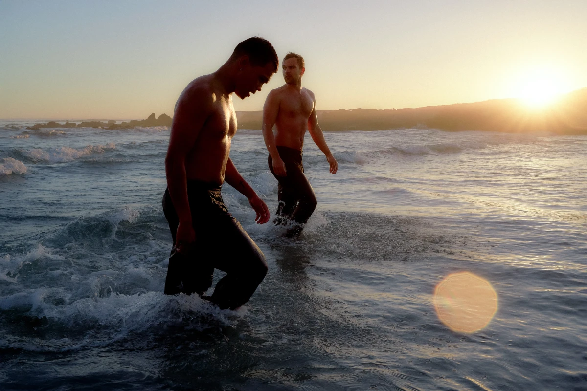 Two people wading through ocean waves in South Africa at sunset for BMW freedom and lifestyle campaign produced by groundglass, Cape Town