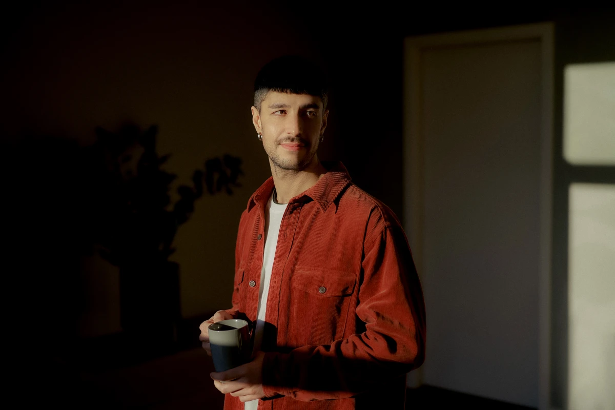 Man in red jacket holding phone in warm interior light for Berlin Senate campaign