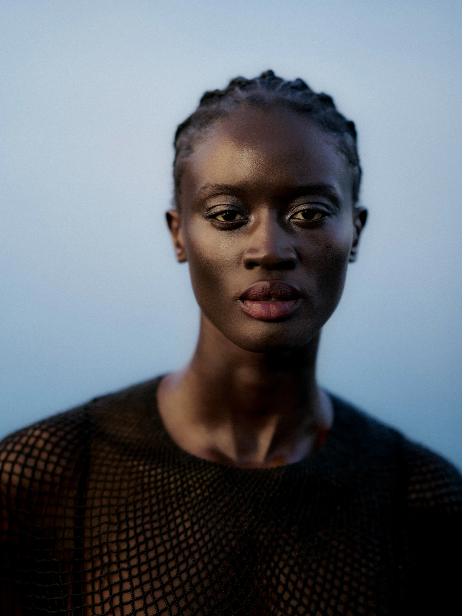 Beauty portrait of a woman with braided hair against soft blue Ocean background for Geske skincare campaign