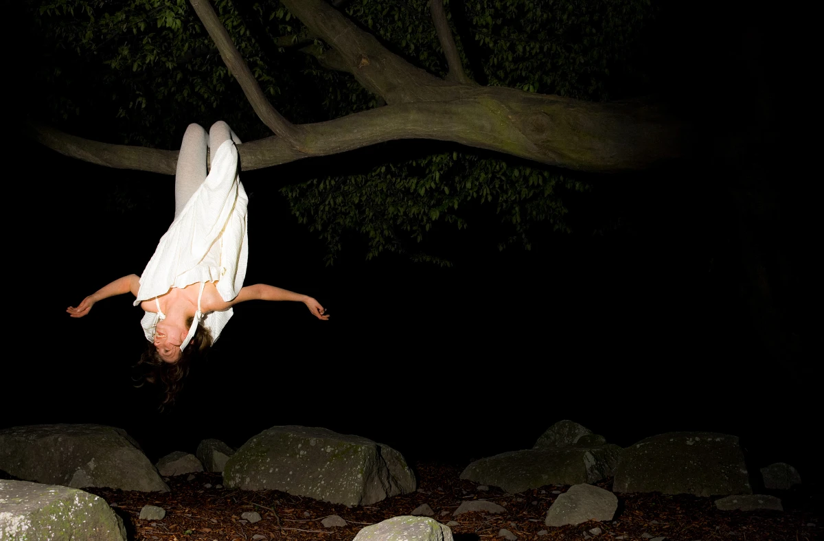 Figure in white dress lying beneath tree at night for T-Mobile conceptual campaign