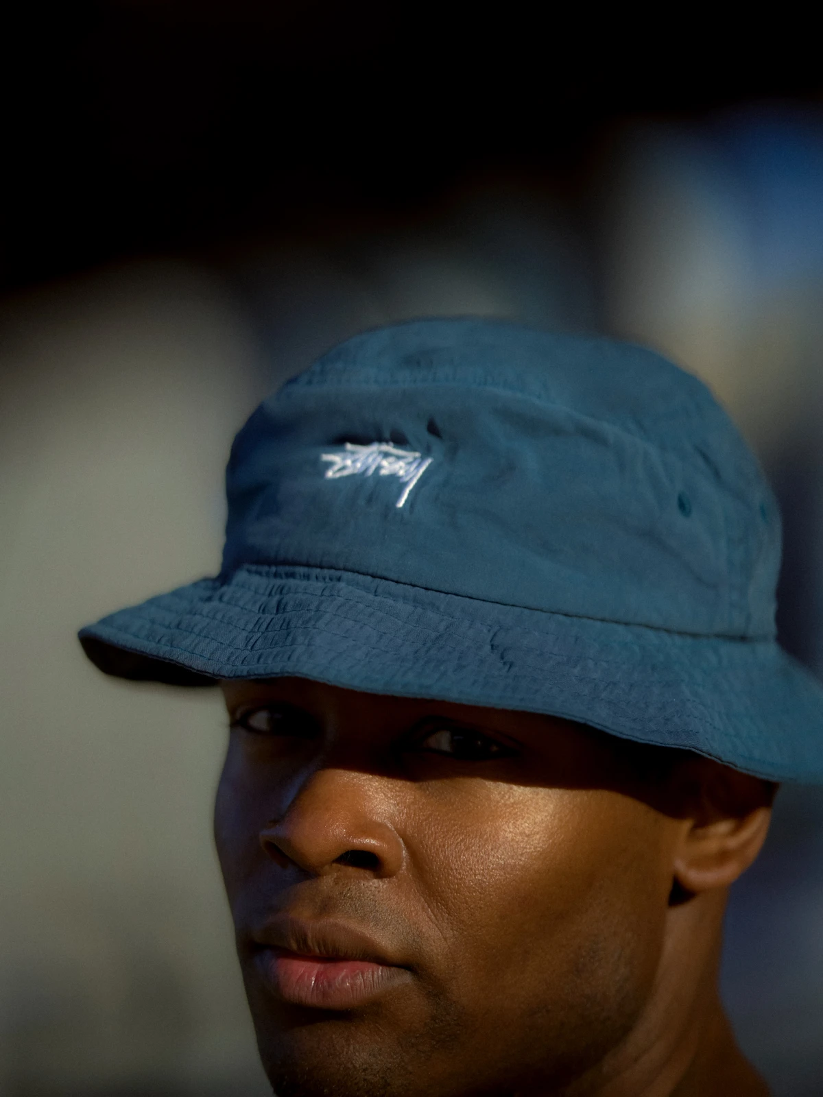Close portrait of man in Stussy bucket hat for streetwear fashion campaign