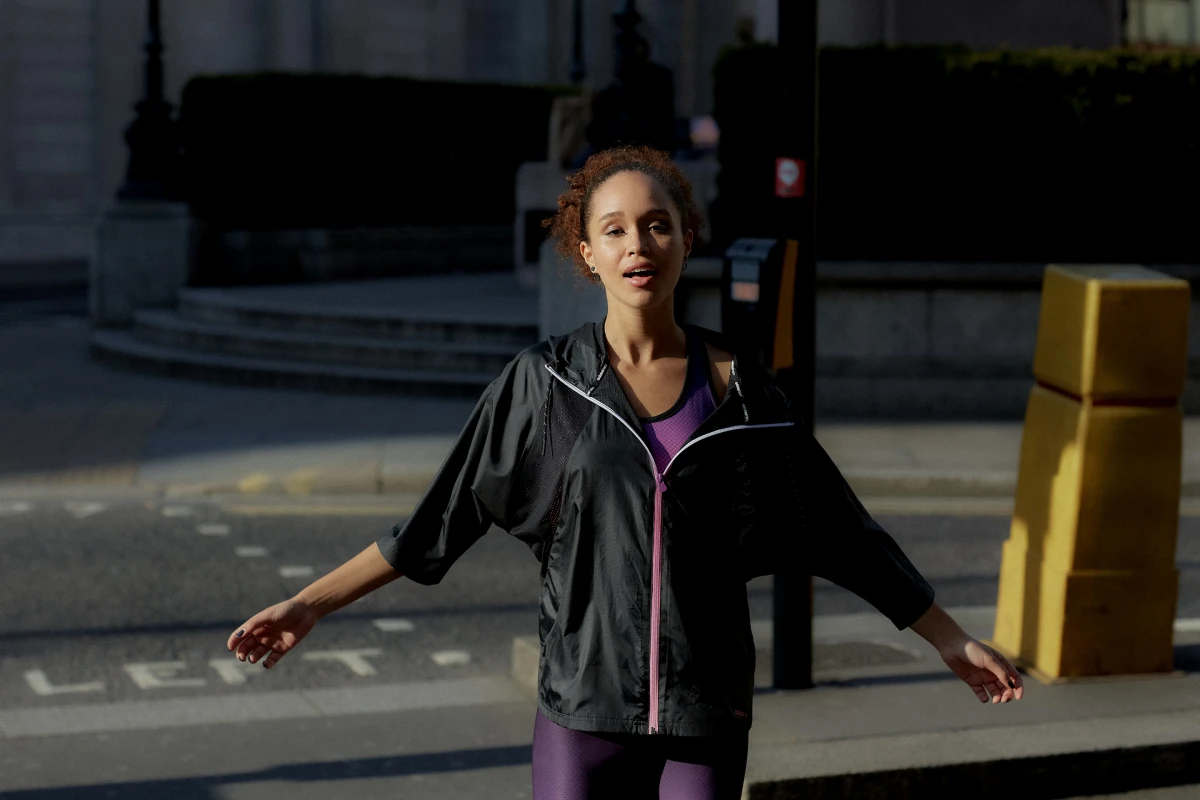 Young woman moving outdoors in black Adidas sportswear at sunset for active lifestyle campaign